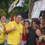 Anton Reyes posing with smiling residents during a community walk in a local neighborhood.