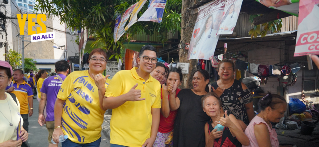 Anton Reyes posing with smiling residents during a community walk in a local neighborhood.